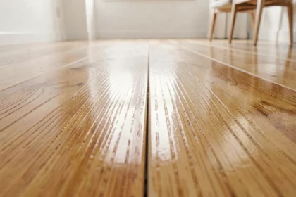 Comparaison entre un parquet ciré à patine mate et un parquet vitrifié brillant, vue en gros plan au sol